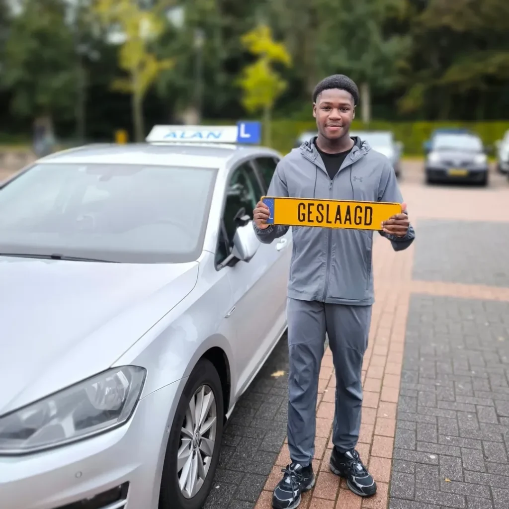 Tahir toont trots zijn GESLAAGD bord na het behalen van zijn rijexamen bij Autorijschool ALAN Tahir toont trots zijn GESLAAGD bord na het behalen van zijn rijexamen bij Autorijschool ALAN